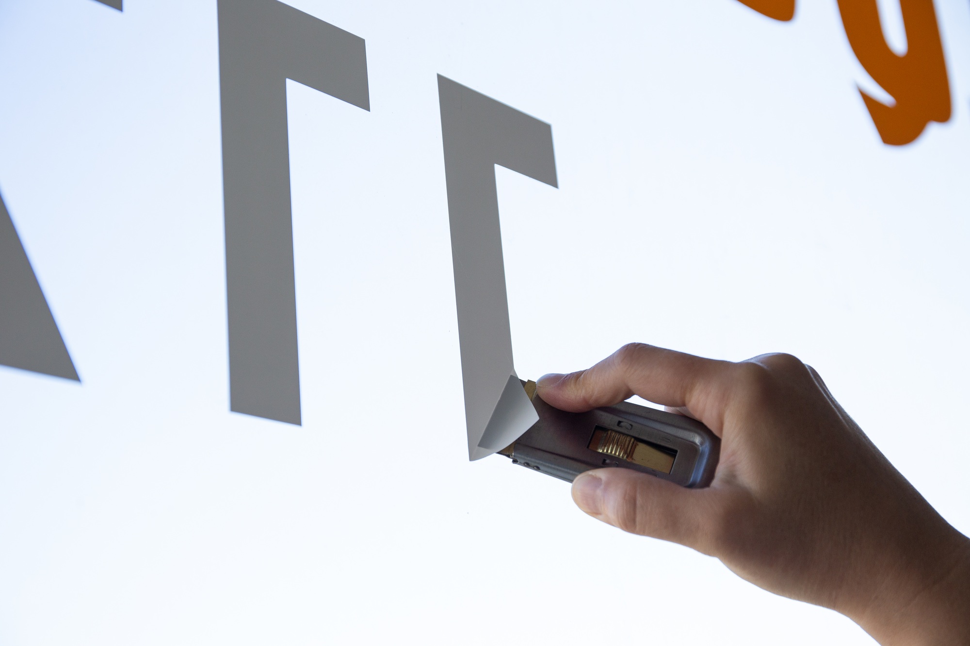 Woman hand removing a vinyl sticker from a window